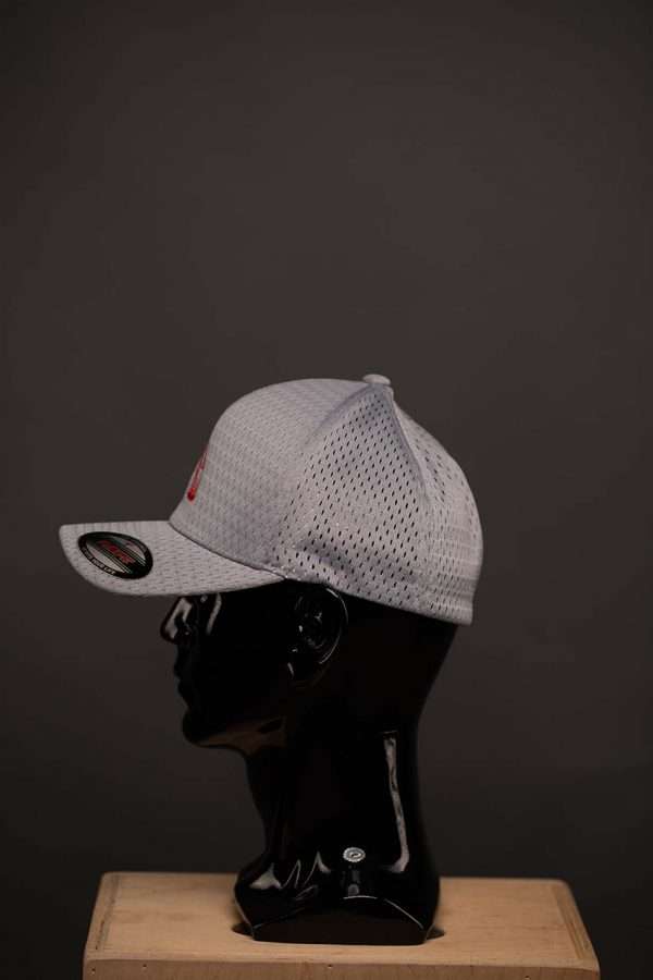 6777 Flexfit Hat Athletic Mesh Cap Silver With Red Ball Logo Side View Flexfit Hat Athletic Mesh Cap