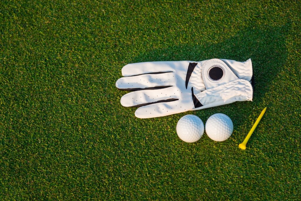 A golf glove on a green golf course.