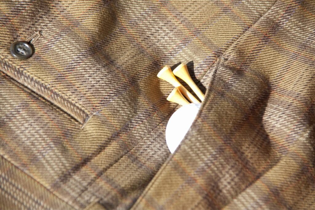 A close up of a pocket with a golf ball featuring golf fall attire.