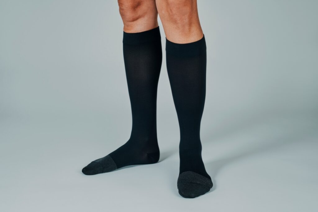 A woman wearing a pair of black compression socks.