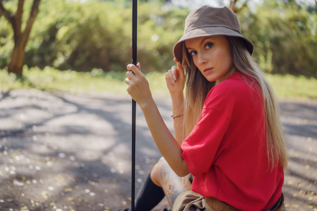 A young woman wearing a bucket hat and holding a golf shaft.