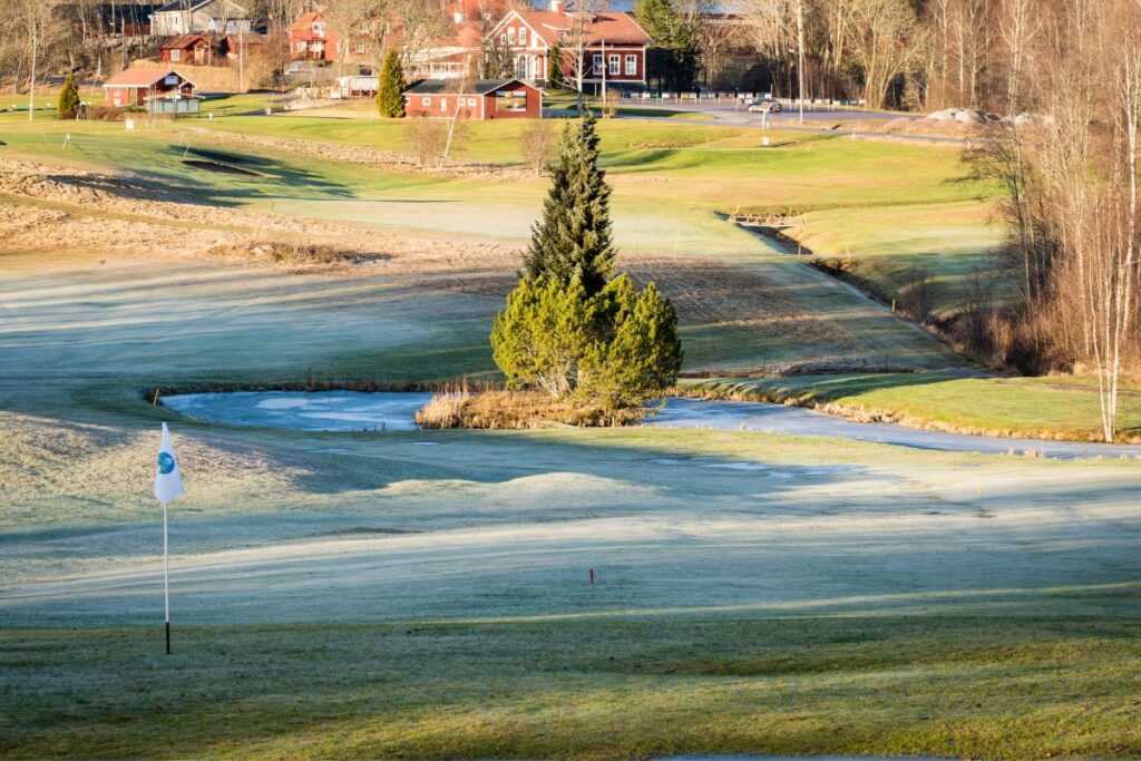 A green golf course transformed into a winter wonderland for golfers.